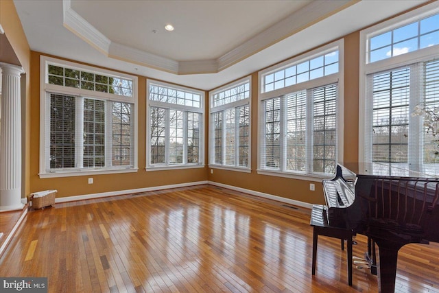 unfurnished sunroom featuring ornate columns, visible vents, and a raised ceiling