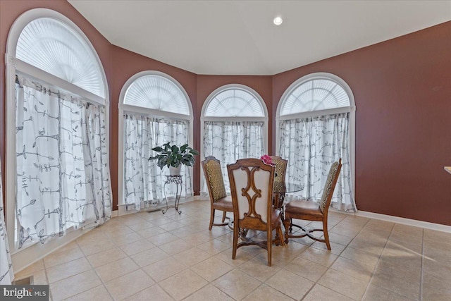 dining space featuring light tile patterned flooring, plenty of natural light, and baseboards