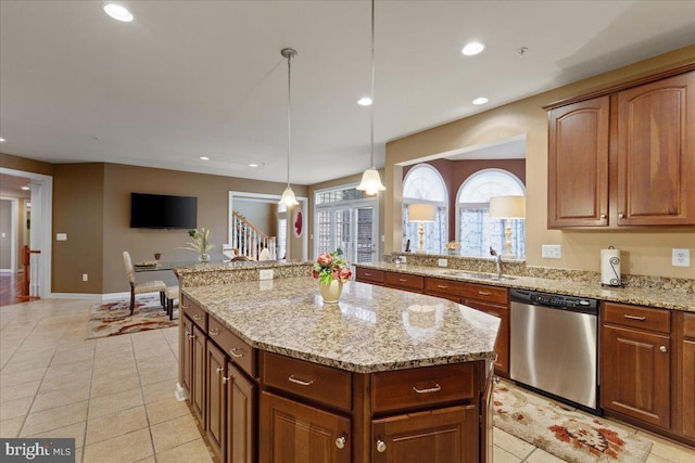 kitchen featuring dishwasher, a kitchen island, light stone countertops, a sink, and recessed lighting