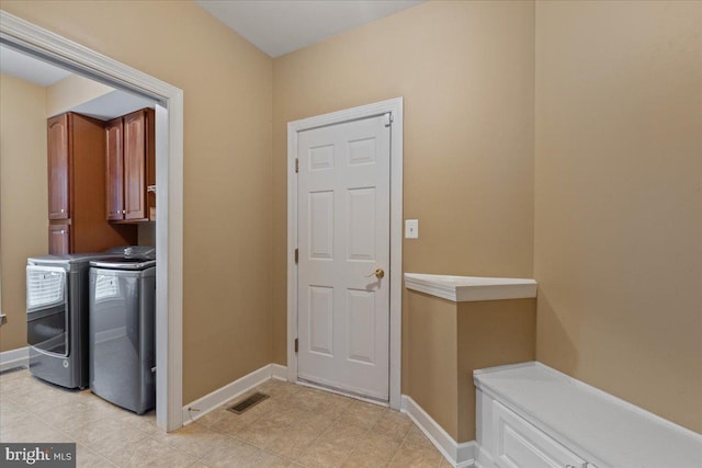 doorway to outside with washing machine and clothes dryer, visible vents, and baseboards