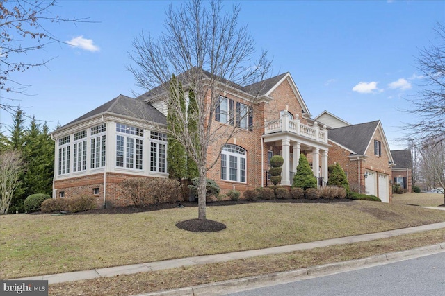 view of front of home featuring a balcony, a garage, a front yard, and brick siding