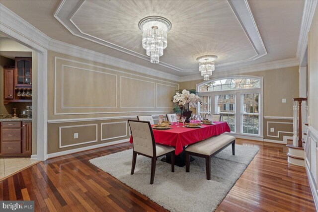 dining space with a notable chandelier, a decorative wall, and hardwood / wood-style floors