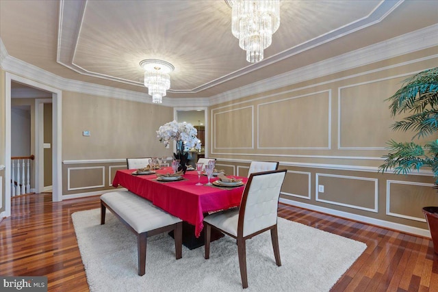 dining space featuring an inviting chandelier, a decorative wall, and wood finished floors