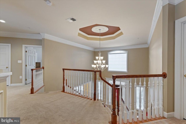 corridor with a chandelier, carpet floors, visible vents, an upstairs landing, and ornamental molding