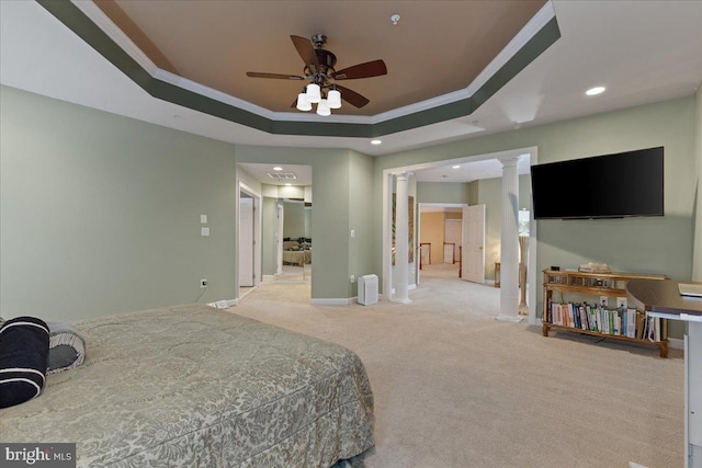 carpeted bedroom with crown molding, a raised ceiling, decorative columns, and baseboards