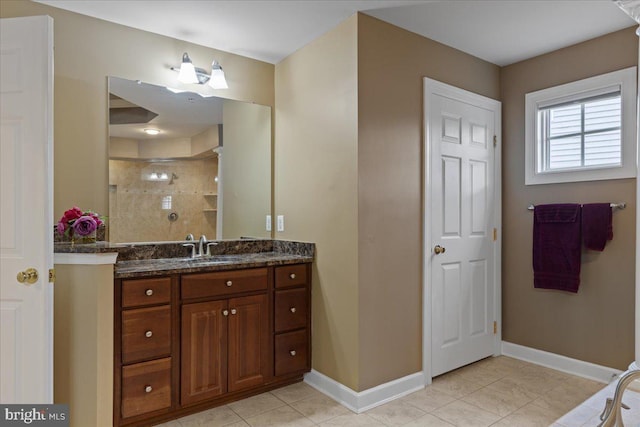 bathroom featuring a stall shower, tile patterned flooring, baseboards, and vanity