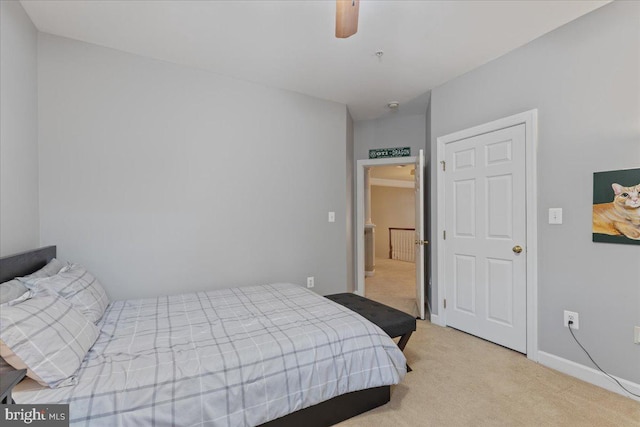 bedroom featuring a ceiling fan, light carpet, and baseboards