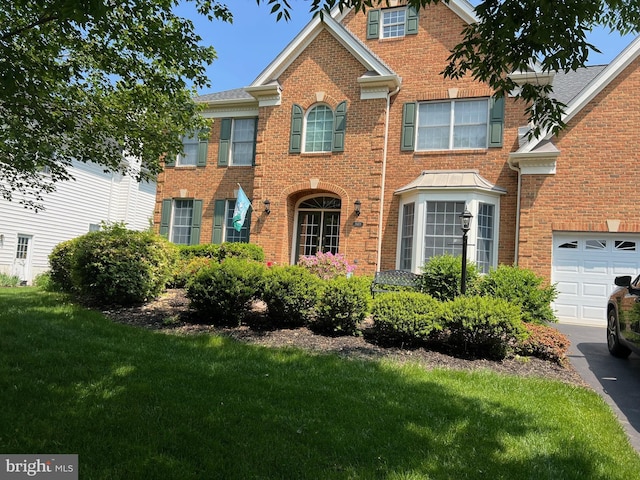 view of front of property with a garage, brick siding, and a front lawn