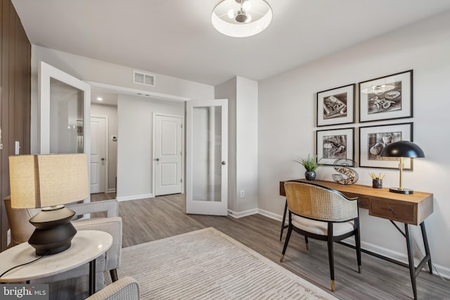 office with wood finished floors, visible vents, and baseboards