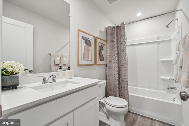 bathroom with shower / bath combo with shower curtain, vanity, toilet, and wood finished floors