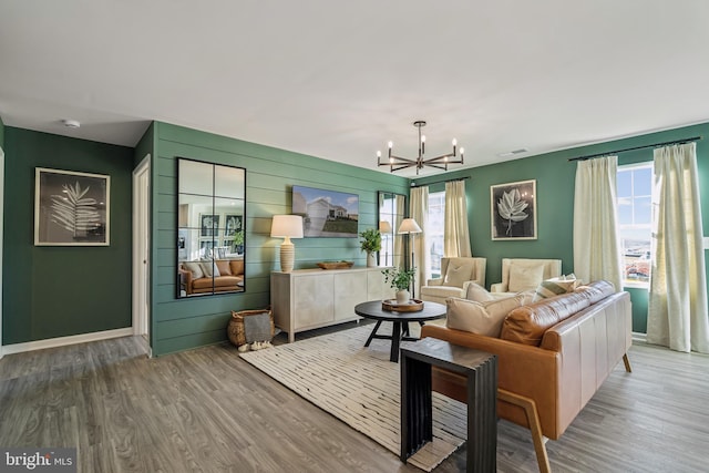 living room featuring a chandelier, wood finished floors, visible vents, and baseboards