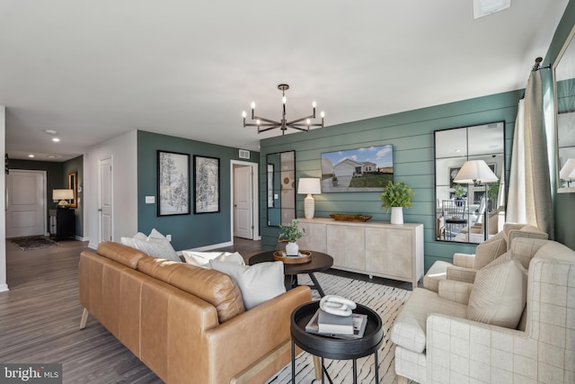 living area featuring wood finished floors, visible vents, and an inviting chandelier