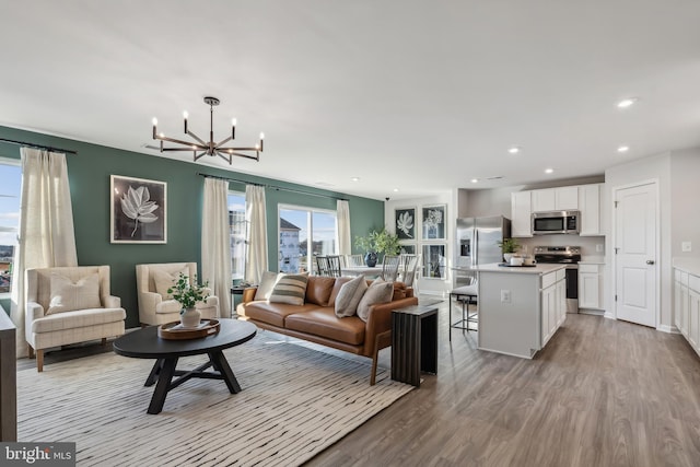 living area featuring recessed lighting, a notable chandelier, and wood finished floors