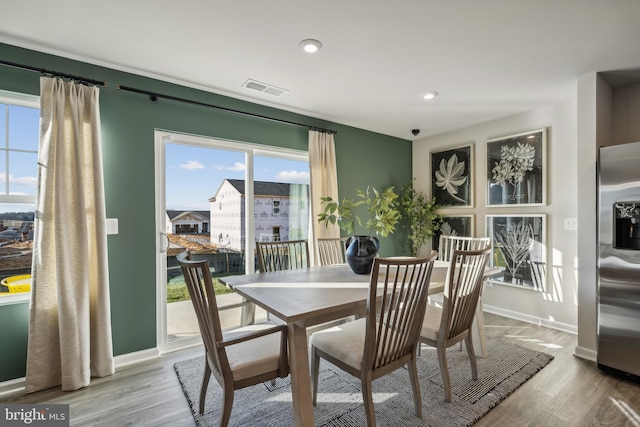 dining space featuring baseboards, visible vents, and wood finished floors