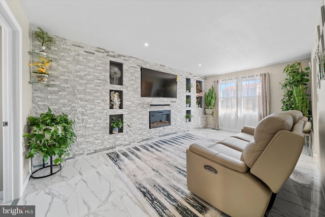 living area with a glass covered fireplace, recessed lighting, and marble finish floor