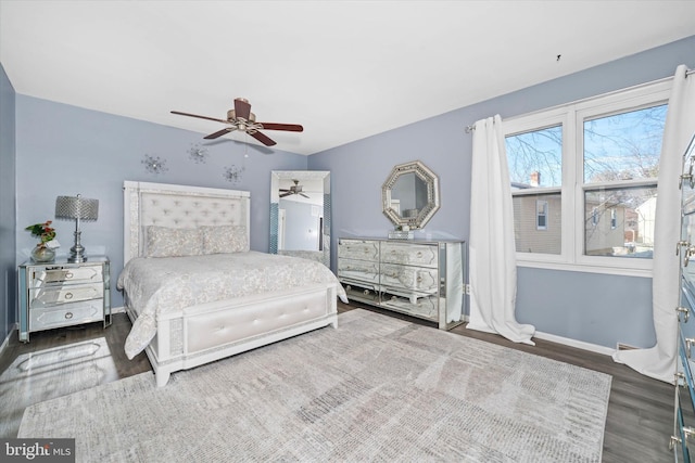 bedroom featuring baseboards, wood finished floors, and a ceiling fan