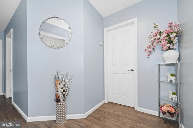 hall featuring baseboards and wood finished floors