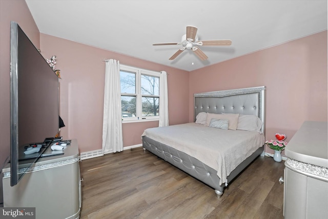 bedroom featuring a ceiling fan, wood finished floors, and baseboards