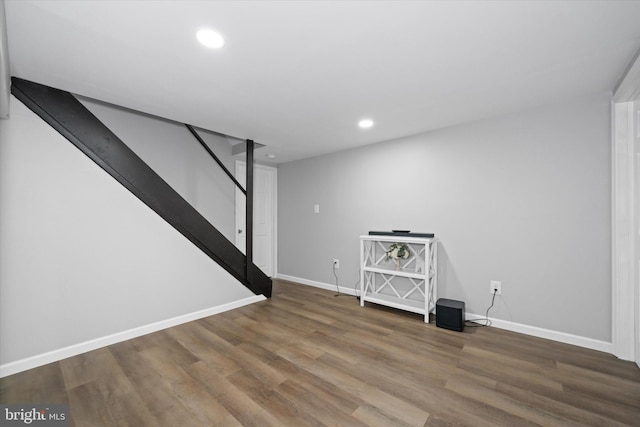 finished below grade area with stairs, recessed lighting, wood finished floors, and baseboards