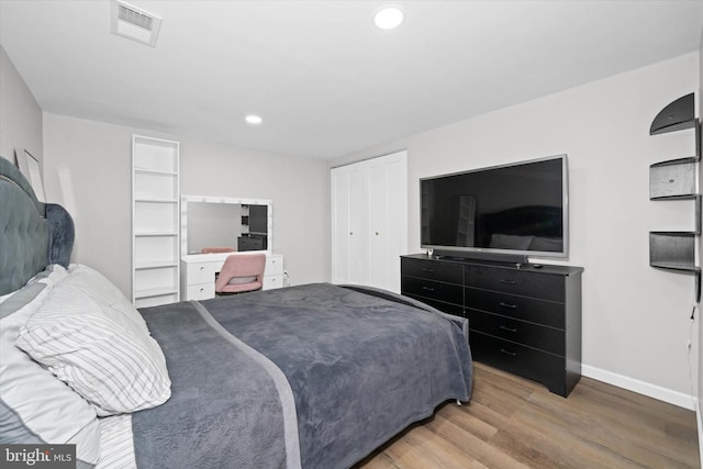 bedroom with visible vents, baseboards, recessed lighting, wood finished floors, and a closet