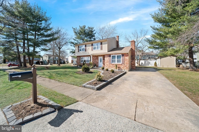 view of front of property with fence, a chimney, a front lawn, concrete driveway, and brick siding