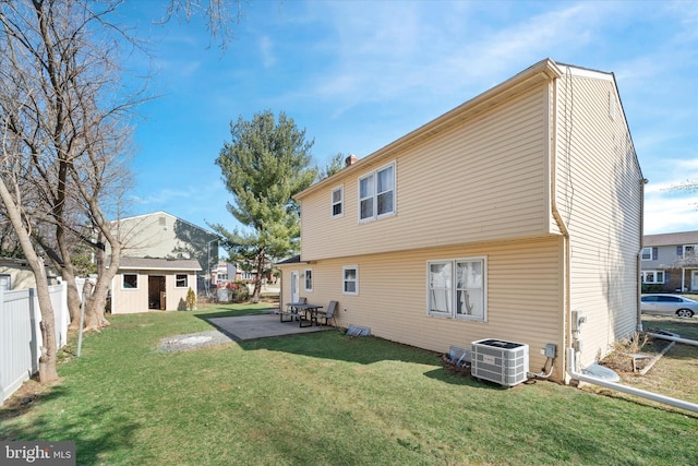 rear view of property with cooling unit, an outbuilding, fence private yard, and a lawn