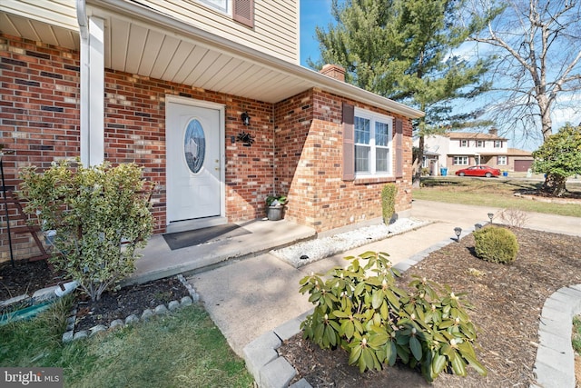 doorway to property featuring brick siding