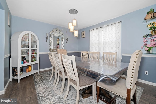 dining room with wood finished floors, baseboards, and a chandelier