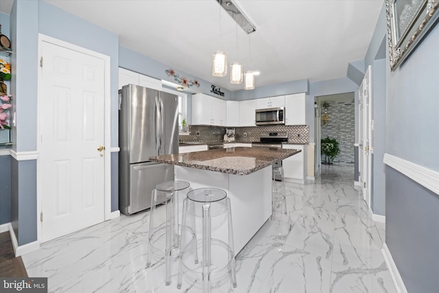 kitchen with tasteful backsplash, marble finish floor, appliances with stainless steel finishes, and white cabinets