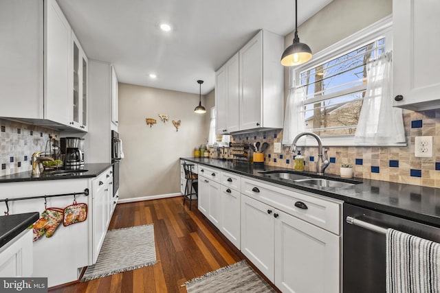 kitchen featuring dark countertops, a sink, and stainless steel dishwasher