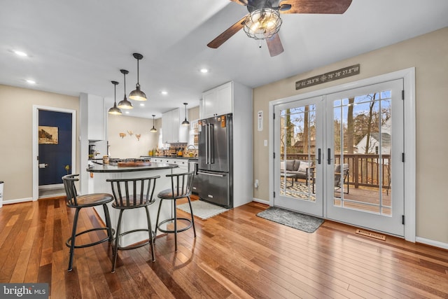 dining room with visible vents, french doors, hardwood / wood-style flooring, and baseboards