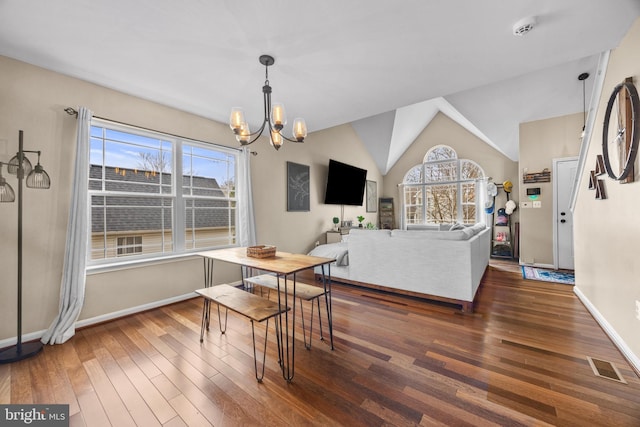 dining space featuring baseboards, visible vents, wood finished floors, vaulted ceiling, and a notable chandelier