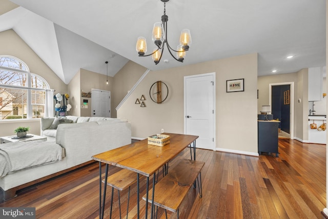 dining space featuring lofted ceiling, baseboards, stairs, hardwood / wood-style floors, and an inviting chandelier