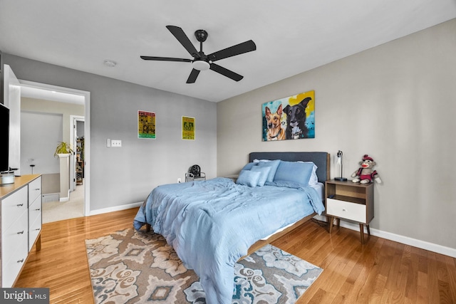 bedroom with light wood-type flooring, baseboards, and a ceiling fan