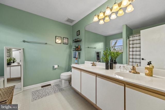 bathroom with toilet, a sink, visible vents, and baseboards