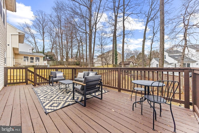 wooden terrace with fence and an outdoor hangout area