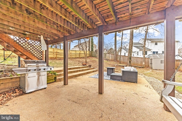 view of patio featuring a grill, a shed, a fenced backyard, and an outbuilding