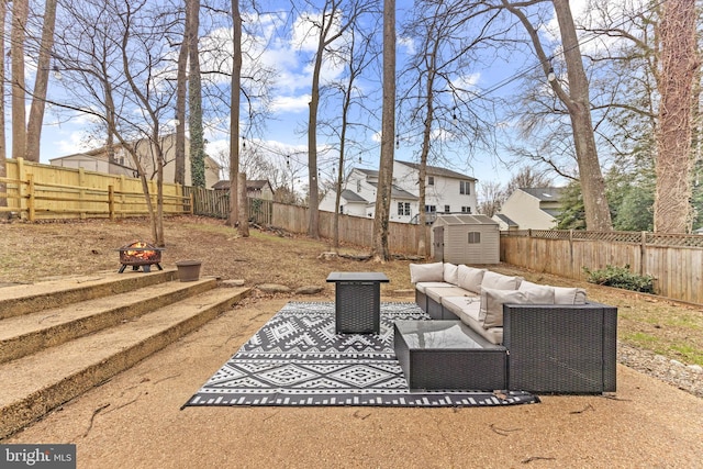 exterior space featuring an outbuilding, a patio, a fenced backyard, a shed, and an outdoor living space with a fire pit