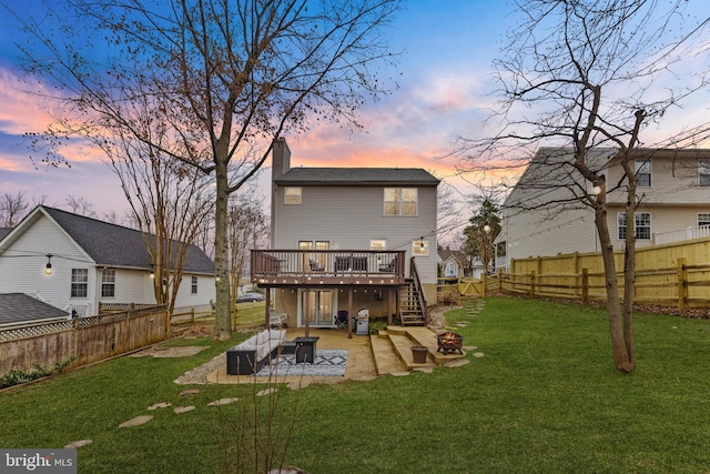 rear view of property with a fire pit, a chimney, a deck, a yard, and a patio area