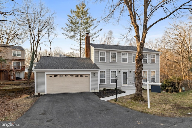 view of front facade with a garage, a shingled roof, a chimney, and aphalt driveway