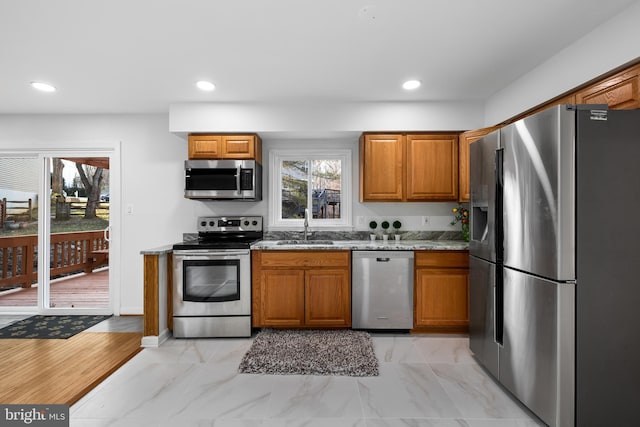 kitchen with brown cabinets, stainless steel appliances, and a sink