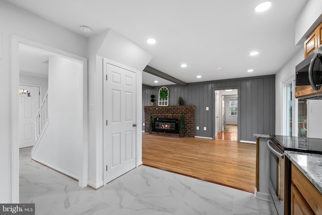 kitchen featuring marble finish floor, a fireplace, stainless steel appliances, and recessed lighting