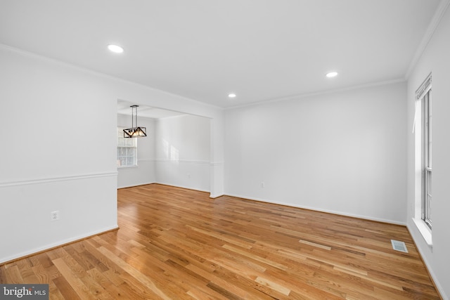 unfurnished room with baseboards, visible vents, light wood-style flooring, crown molding, and recessed lighting