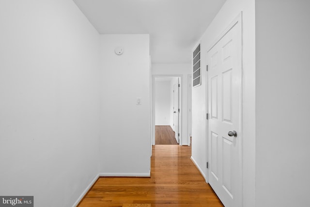 hall featuring wood finished floors and baseboards