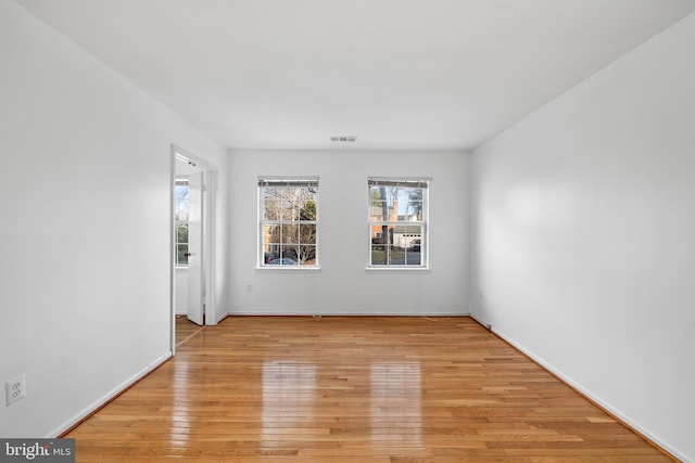 spare room with light wood-style floors and visible vents