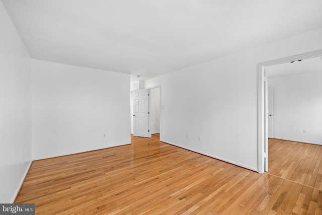 unfurnished room with light wood-style flooring and baseboards