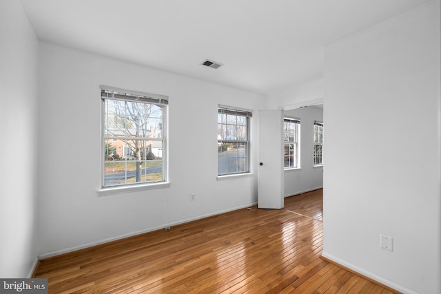 unfurnished room with baseboards, visible vents, and light wood finished floors