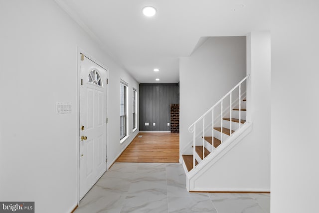 entryway with marble finish floor, recessed lighting, stairway, wooden walls, and baseboards