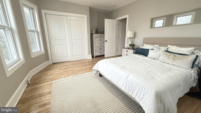 bedroom featuring a closet, baseboards, and wood finished floors