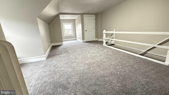 additional living space with carpet floors, vaulted ceiling, and baseboards